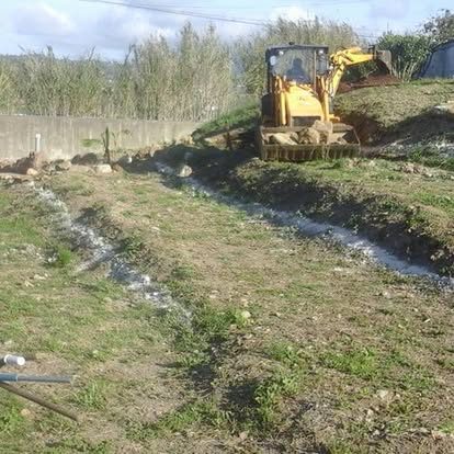 Excavator performing drainage trench work